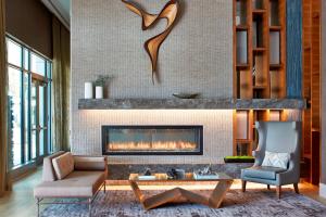 a living room with a fireplace and a couch and a chair at AC Hotel by Marriott Atlanta Buckhead at Phipps Plaza in Atlanta