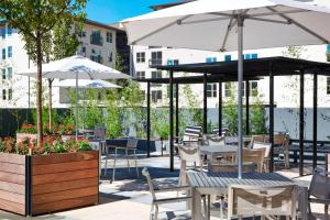 a patio with tables and chairs and umbrellas at AC Hotel by Marriott Atlanta Buckhead at Phipps Plaza in Atlanta