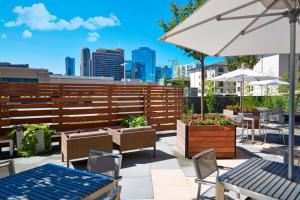 a patio with tables and chairs and an umbrella at AC Hotel by Marriott Atlanta Buckhead at Phipps Plaza in Atlanta