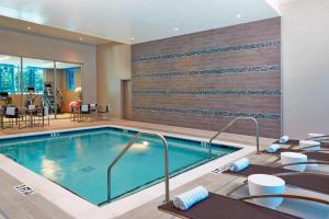 a pool in a hotel room with tables and chairs at AC Hotel by Marriott Atlanta Buckhead at Phipps Plaza in Atlanta