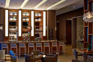 a bar in a restaurant with chairs and tables at AC Hotel by Marriott Atlanta Buckhead at Phipps Plaza in Atlanta