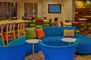 a blue couch with colorful pillows in a restaurant at Fairfield Inn & Suites Boca Raton in Boca Raton