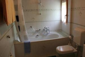 La salle de bains est pourvue d'une baignoire, de toilettes et d'une fenêtre. dans l'établissement Alpe Monte Massella, à Poschiavo
