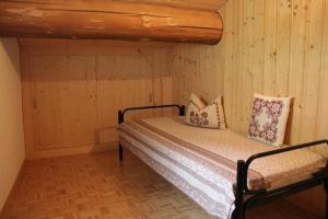 - une chambre avec un lit et un mur en bois dans l'établissement Alpe Monte Massella, à Poschiavo