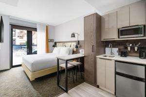 a hotel room with a bed and a kitchen at TownePlace Suites by Marriott New York Manhattan/Chelsea in New York