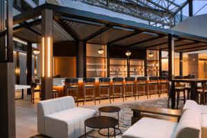 羅穆盧斯的住宿－底特律大都會喜來登酒店機場店，一间酒吧,配有白色的沙发和酒吧凳子