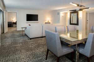 a living room with a dining table and a couch at Sheraton Detroit Metro Airport in Romulus