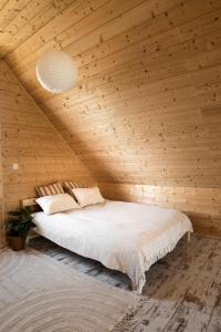a bedroom with a bed in a wooden ceiling at Między Falami in Łazy
