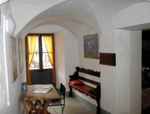 a living room with a table and a bench in a room at Ferienwohnung - a85554 in Promontogno
