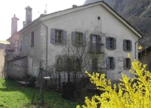 an old house with a fence in front of it at Ferienwohnung - a85554 in Promontogno