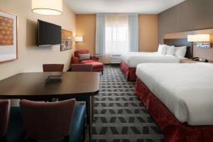 um quarto de hotel com duas camas e uma mesa e cadeiras em TownePlace Suites Fresno Clovis em Clovis