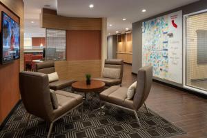 a waiting room with chairs and a large screen at TownePlace Suites Fresno Clovis in Clovis