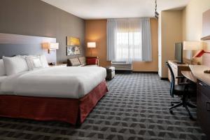 クローヴィスにあるTownePlace Suites Fresno Clovisのベッドとデスクが備わるホテルルームです。