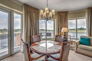 a dining room with a table and chairs and windows at Huge Luxury 2/2 AAA Four Diamond Resort by Luxury Beach Rentals in Myrtle Beach