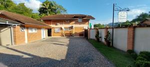 a driveway leading to a house with a fence at Pousada Agradável Pomerode in Pomerode