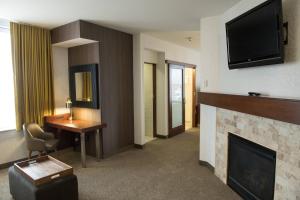 Habitación de hotel con chimenea y TV en SpringHill Suites by Marriott Logan, en Logan