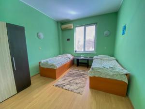 2 camas en una habitación con paredes verdes en Пансион - Димитър Хадживасилев en Svishtov