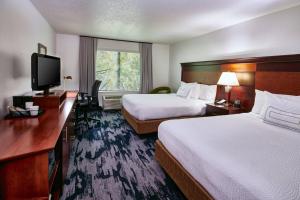 a hotel room with two beds and a flat screen tv at Fairfield Inn & Suites Detroit Livonia in Livonia