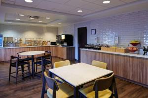 a restaurant with two tables and chairs and a counter at Fairfield Inn & Suites Detroit Livonia in Livonia