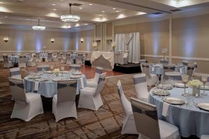 a banquet hall with tables and white chairs and tablesearcher at Detroit Marriott Southfield in Southfield