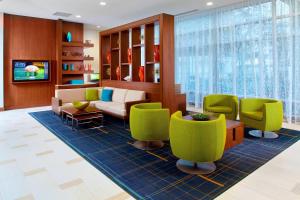 a lobby with a waiting room with green chairs at Courtyard by Marriott Orlando Lake Nona in Orlando