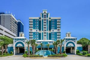 een groot blauw gebouw met palmbomen ervoor bij Ocean Blue 902 in Myrtle Beach