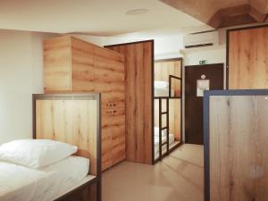 a bedroom with a bed and a wooden wall at GARAGE HOSTEL in Nova Gorica