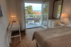 sypialnia z łóżkiem oraz balkon ze stołem i krzesłami w obiekcie Premium Apartments Punta Kolova w mieście Opatija