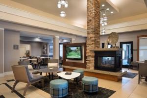un vestíbulo con chimenea, mesas y sillas en Residence Inn by Marriott Camarillo, en Camarillo
