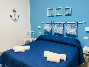 a blue bedroom with a blue bed with two white pillows at Casa Alice in Cefalù