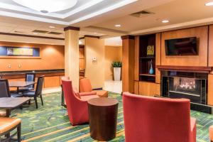 un vestíbulo con chimenea, mesas y sillas en Fairfield Inn & Suites by Marriott Muskegon Norton Shores en Norton Shores