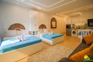 two beds in a hotel room with a kitchen at SeaView Turtles in Hurghada