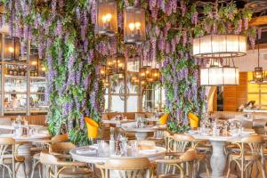 オックスフォードにあるCourtyard by Marriott Oxford City Centreの花の壁にテーブルと椅子が備わるレストラン