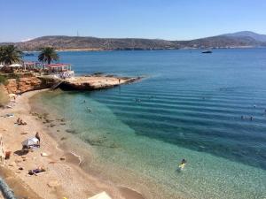 einen Strand mit Menschen, die im Wasser schwimmen in der Unterkunft Serena at Athens Riviera in Vari
