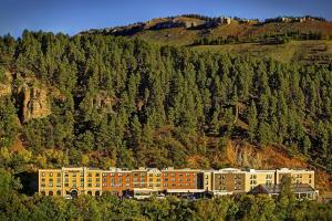 a large building in front of a mountain at SpringHill Suites by Marriott Deadwood in Deadwood