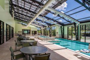 una piscina cubierta con mesas y sillas junto a una piscina en SpringHill Suites by Marriott Deadwood, en Deadwood