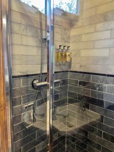a bathroom with a shower with a glass door at Skipbridge Farm Glamping in Green Hammerton