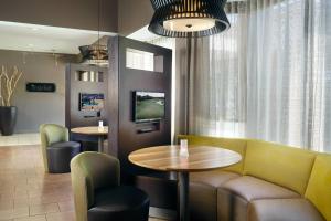 a waiting room with a table and chairs and a tv at Courtyard by Marriott Macon in Macon