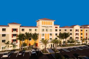 un bâtiment avec des palmiers en face d'un parking dans l'établissement TownePlace Suites by Marriott Fort Myers Estero, à Estero