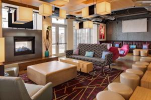a lobby with a couch and chairs and a fireplace at Aloft Tucson University in Tucson