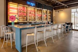 a bar with a bunch of stools in a room at Aloft Tucson University in Tucson