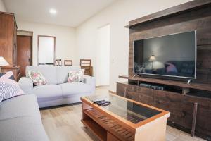 a living room with a large flat screen tv at Recreio Paradisíaco in Rio de Janeiro