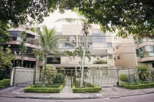 a building with palm trees in front of it at Recreio Paradisíaco in Rio de Janeiro