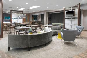 een lobby met tafels en stoelen en een cafetaria bij SpringHill Suites by Marriott Kansas City Lenexa/City Center in Lenexa