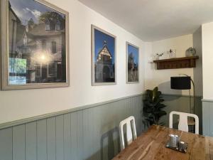 a dining room with a table and some pictures on the wall at The Railway Cottage Bridgnorth in Bridgnorth