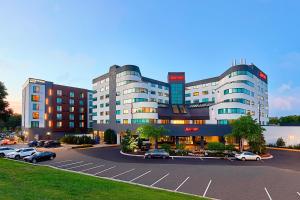 un grand bâtiment avec des voitures garées dans un parking dans l'établissement Minneapolis Marriott West, à Saint Louis Park