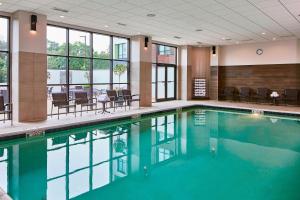 a swimming pool in a building with chairs and tables at Minneapolis Marriott West in Saint Louis Park