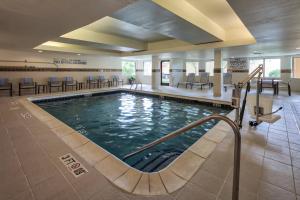 una piscina en un edificio con sillas y mesas en Courtyard by Marriott Rock Hill, en Rock Hill