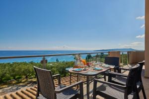 un tavolo e sedie su un balcone con vista sull'oceano di Pelagaki Sunrise a Orthoniaí