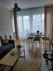 a living room with a table and a couch at Appartement cosy au Tréport 2 à 4 personnes in Le Tréport